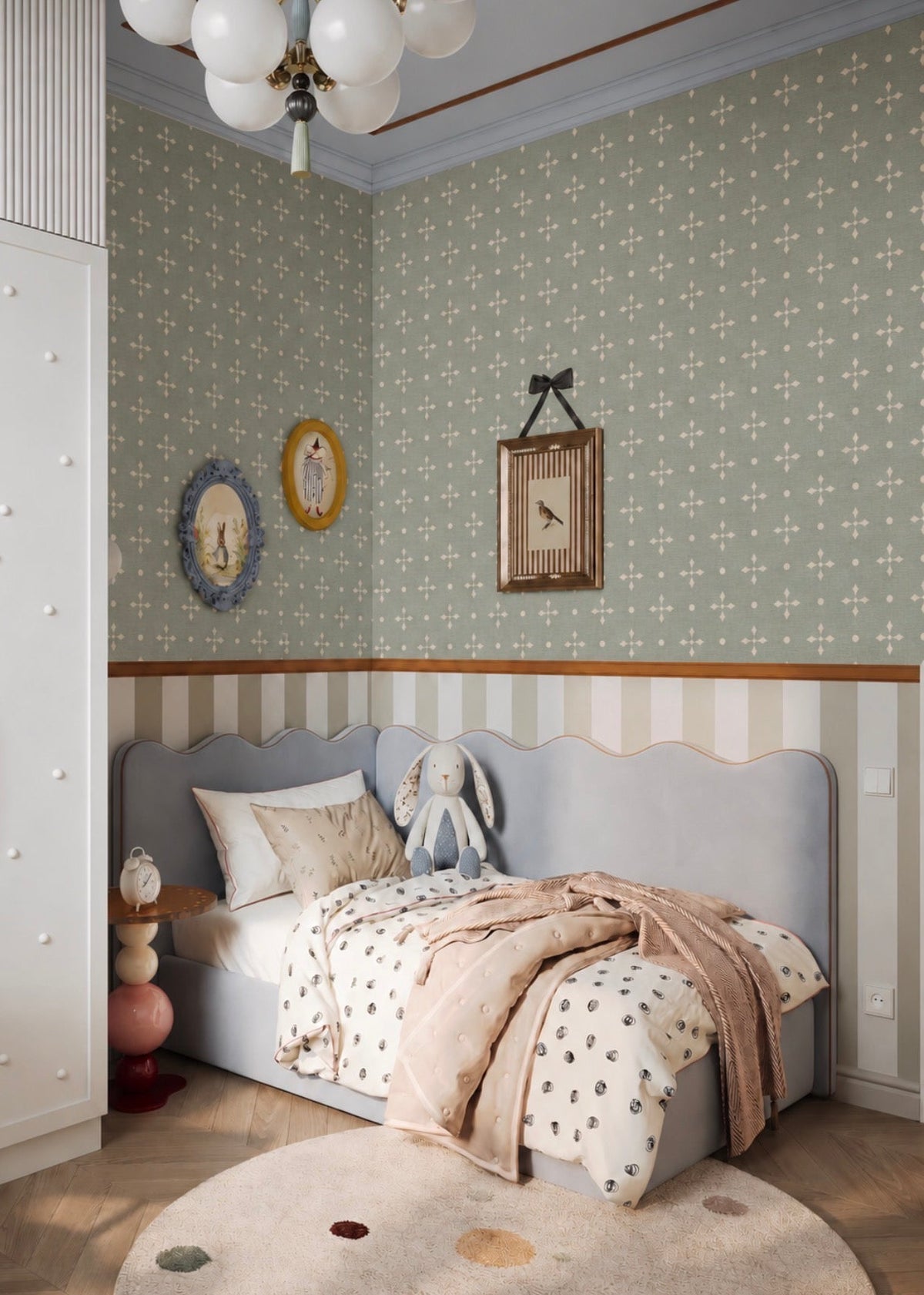 Papel mural Clementine Star verde salvia con estrellas y círculos crema en un rincón de estudio infantil con escritorio de madera.