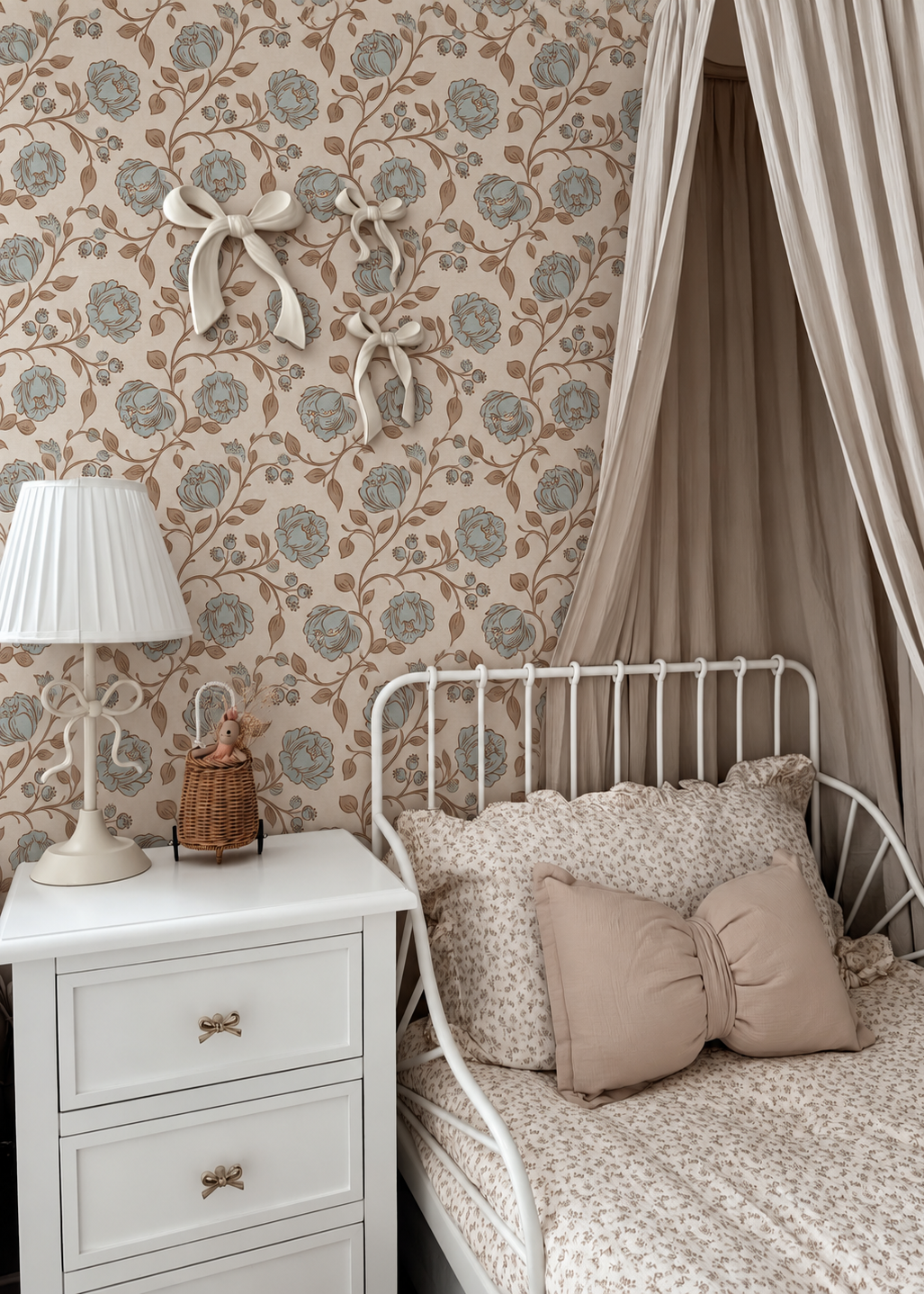 Papel mural Clementine Floral con flores azul grisáceo y ramas café sobre fondo crema en un dormitorio infantil con cama blanca y dosel.